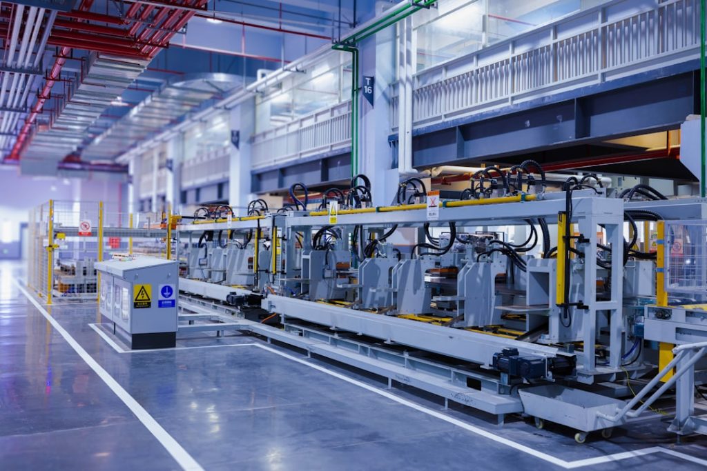 A view of the refrigerator manufacturing plants fully automated side panel forming line.Translation: Warning:Danger Prohibit reach into;elecric shock;must connect an earth terminal to the ground
